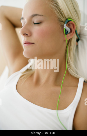 Donna ascoltando la musica attraverso le cuffie. Foto Stock