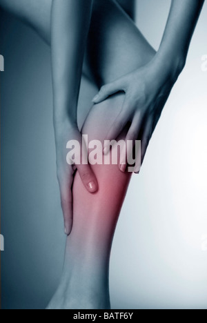 La parte inferiore della gamba del dolore, immagine concettuale.donna il suo massaggio polpacci doloranti. Foto Stock
