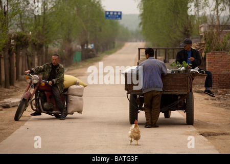 Changchun provincia di Jilin Cina un vegitable e commerciante di frutta la vendita dal retro del suo tre ruote Foto Stock