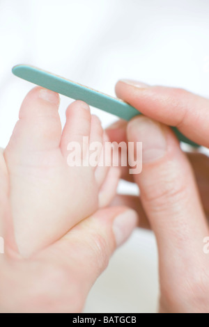 Il taglio toenails. 7 mesi Baby girl avente il suo toenails tagliato. Foto Stock