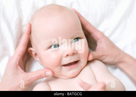 Baby massaggio. Massaggio mani la testa di un 7 mesi Baby girl. Foto Stock