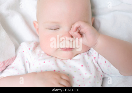 Stanco bambino. 7 mesi Baby girl strofinando il suo occhio. Foto Stock