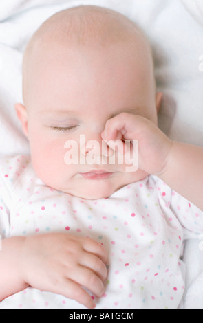 Stanco bambino. 7 mesi Baby girl strofinando il suo occhio. Foto Stock