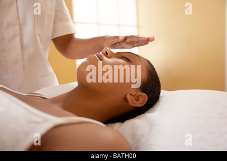 La guarigione spirituale.guaritore spirituale il trattamento di un client. Lei sta usando le mani al canale una energia di guarigione dal suo corpo. Foto Stock