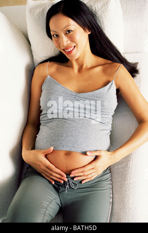 Donna incinta mentre tiene il suo ventre gonfio. Foto Stock