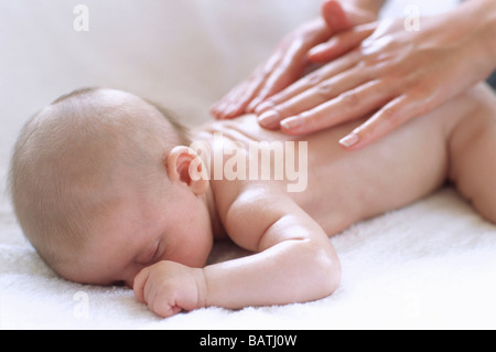 Baby massaggio. Mani massagingthe indietro di 2 mese-vecchio baby boy. Foto Stock