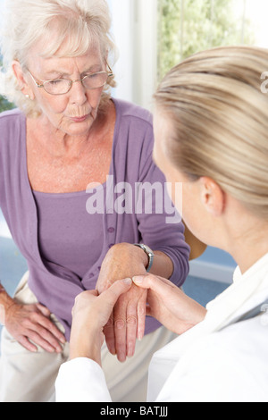 Artrite reumatoide.medico di medicina generale di esaminare una mano del paziente per segni di artrite reumatoide. Foto Stock