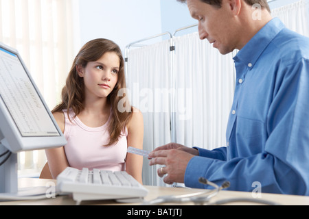 La contraccezione adolescenti. Pratica generale medico discutendo oralcontraception con un adolescente. Foto Stock