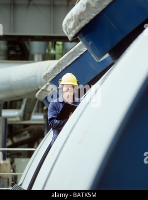 La stazione di alimentazione. Lavoratore accantoall una turbina in una centrale elettrica a gas.fotografato in Scozia. Foto Stock