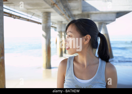 Donna asiatica sotto il molo a beach Foto Stock