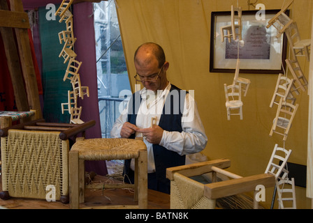 Artigiano la realizzazione di una sedia in una fase di stallo in spagnolo festival in Manchester REGNO UNITO Foto Stock