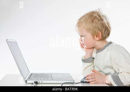 Il toddler boy lavorando sul computer portatile Foto Stock