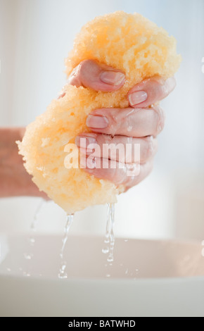 Close-up di donna di mano spugna di schiacciamento Foto Stock