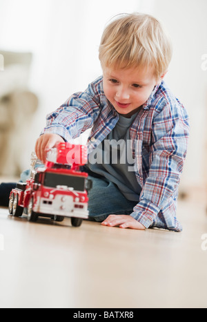 Ragazzo (4-5) giocando con toy motore Fire Foto Stock