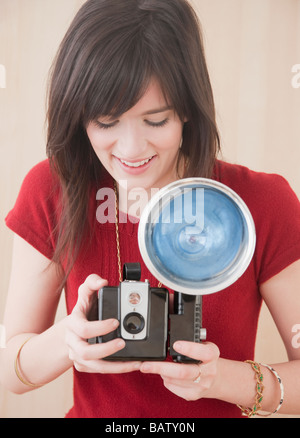 Giovane donna con fotocamera, studio shot