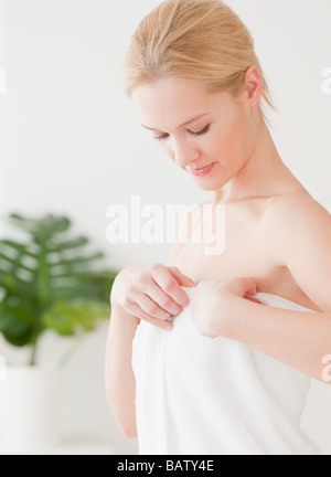 Giovane donna avvolta in asciugamano Foto Stock