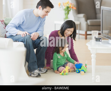 Il padre e la madre gioca con nostra figlia nel soggiorno Foto Stock