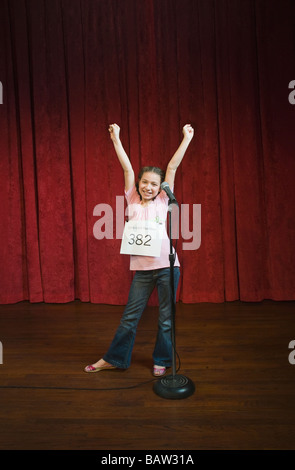 Razza mista ragazza in competizione in ape di ortografia Foto Stock