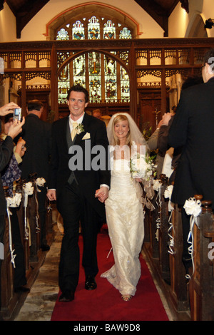 Giovane coppia di sposi novelli a piedi giù per la navata della chiesa North Yorkshire. Modello Regno Unito rilasciato Foto Stock