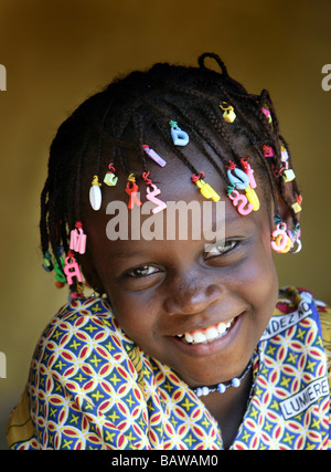 Ragazza sorridente con lettere nel suo dreadlocks, Guinea, Africa occidentale Foto Stock