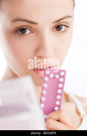 Giovane donna tenendo le pillole contraccettive Foto Stock