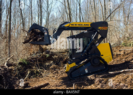 New Holland C 175 tracked minipala caricatrice spazzola di compensazione su un lotto residenziale Foto Stock