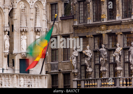 La bandiera di Bruxelles nella Grand Place con intricati intarsi in pietra dietro - Bruxelles, Belgio Foto Stock