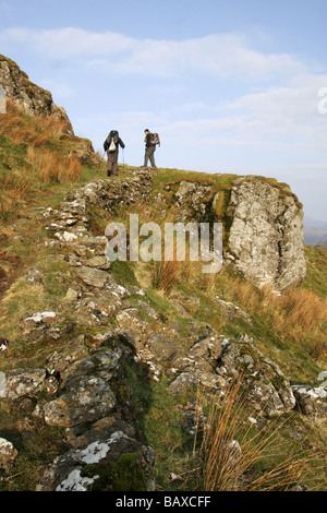 A Piedi nel paese deserto trail scalare le montagne rocciose, erba percorso coperto sul lato della collina,migliaia di piedi-up Foto Stock