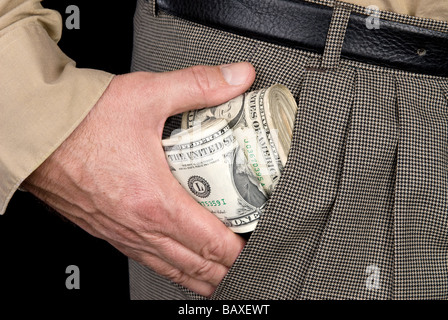 Un uomo stoffe mazzette di contanti in tasca Foto Stock