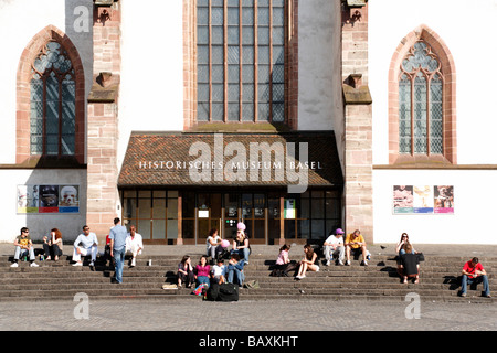 Un gruppo di giovani seduti sui gradini davanti a una chiesa, Chiesa Barfuesser, Museo Storico, Barfuesserplatz, Basilea, Swi Foto Stock