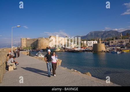 Un giovane passeggiando lungo la promenade, Kyrenia porto e castello di Kyrenia, Kyrenia, Girne, a nord di Cipro, Cipro Foto Stock