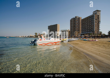 Barche sulla spiaggia di Varosha con le rovine di abbandono di alberghi in background, città fantasma, Famagosta, Ammochostos, Gazimagusa, Nord C Foto Stock