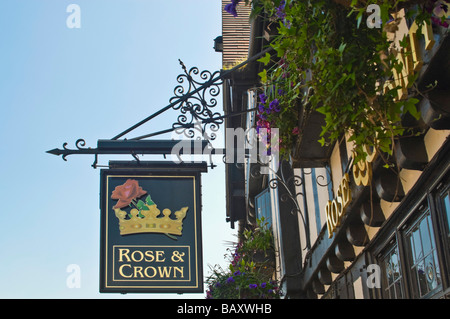 Chiudere orizzontale di un tradizionale vecchio ferro battuto [Rose and Crown] pub segno appeso contro un luminoso cielo blu Foto Stock