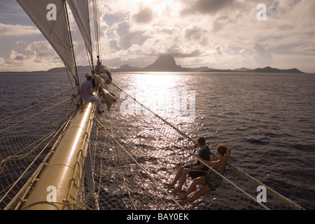 Persone relax su bompresso e in netto di vela Cruiseship Star Flyer (Star Clippers Crociere), Bora Bora, Isole della Società, Fre Foto Stock