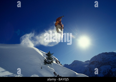 Uno snowboarder durante un salto in avanti di un cielo blu Foto Stock