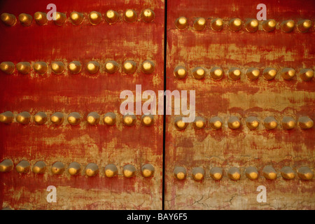 In prossimità di una porta del tempio, doppia porta rossa con Giallo rotondo decorazioni, Cina Foto Stock