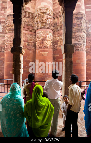 I turisti indiani a Qutb Minar tramite pilastri indù a Qutb Minar a Delhi in India Foto Stock