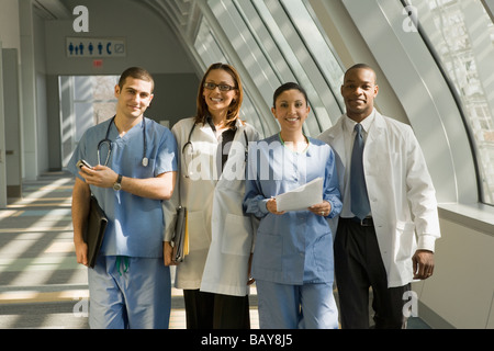 Multi-etnico medici e infermieri che pongono in corridoio Foto Stock