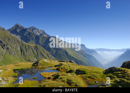 Piccolo lago con Habicht in background, banco di nebbia in Valle Gschnitztal, Stubaier Alpen gamma, Stubai, Tirolo, Austria Foto Stock