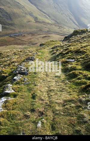 A Piedi nel paese deserto trail scalare le montagne rocciose, erba percorso coperto sul lato della collina,migliaia di piedi-up. Foto Stock