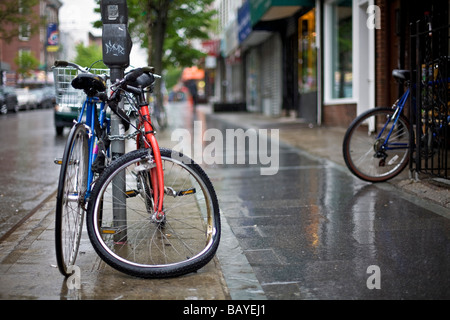 Bicicletta con ruota inclinata concatenati a un sondaggio Foto Stock