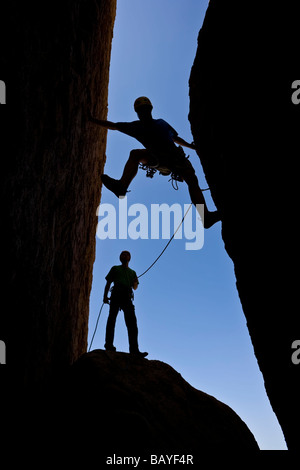 Un team di arrampicatori si stagliano in quanto lavorano a loro modo su un camino Foto Stock