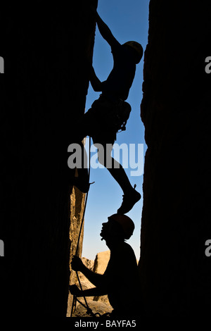 Un team di arrampicatori si stagliano in quanto lavorano a loro modo su un camino Foto Stock