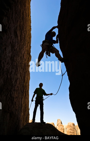 Un team di arrampicatori si stagliano in quanto lavorano a loro modo su un camino Foto Stock