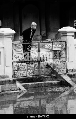 Un uomo guarda nel pozzo celeste della chiarezza presso il Tempio della Letteratura ad Hanoi, Repubblica Socialista del Vietnam. Foto Stock