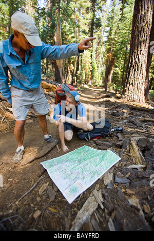 Due escursionisti di consultare la loro mappa lungo il sentiero Foto Stock
