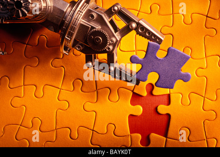 Il braccio di robot holding puzzle pezzo Foto Stock
