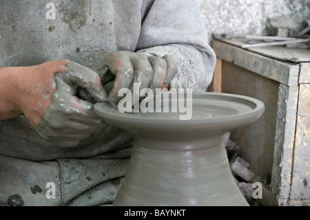 Uomo di gettare un piatto di terracotta in fabbrica nei pressi di Fez, Marocco Foto Stock