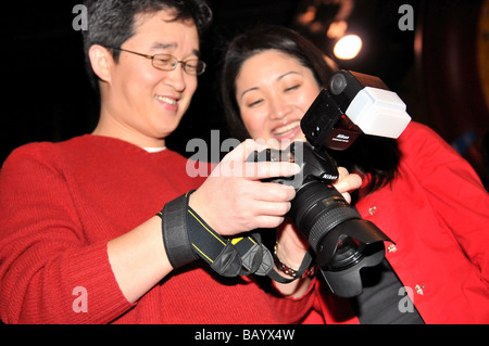 Gioioso fotografo asiatico con una reflex digitale. Foto Stock