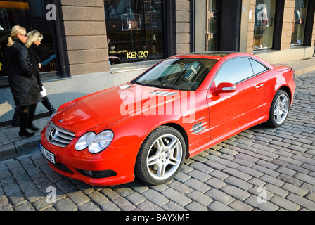Rosso di lusso auto al di fuori dei negozi costosi nella sistemazione di zona di Tallinn, Estonia. Foto Stock